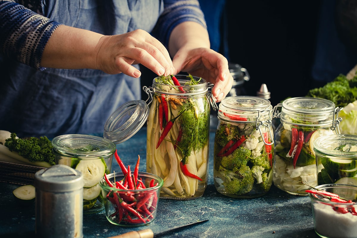 Canning green beans with red hot chili peppers in glass jars