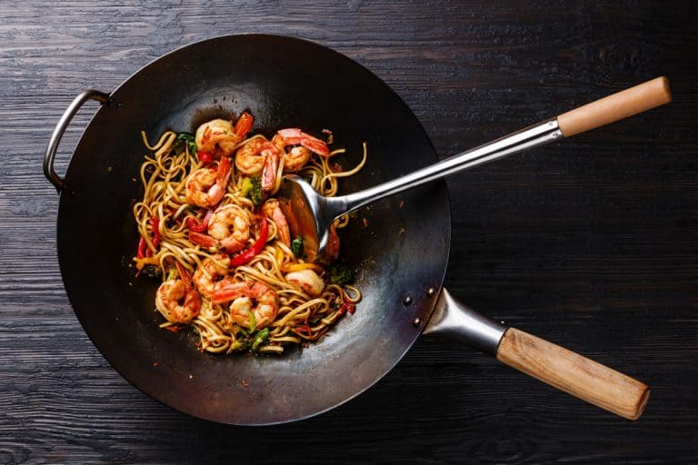 Stir fry udon with shrimps cooked on wok with spatula for mixing, Should A Wok Be Nonstick?