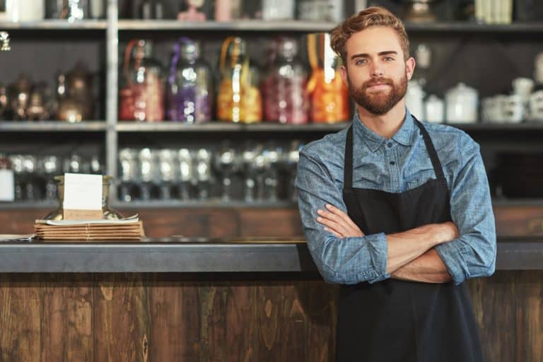 Man with attractive beard wearing black apron as a kitchen gift to him, 27 Awesome Kitchen Gifts for the Man in Your Life