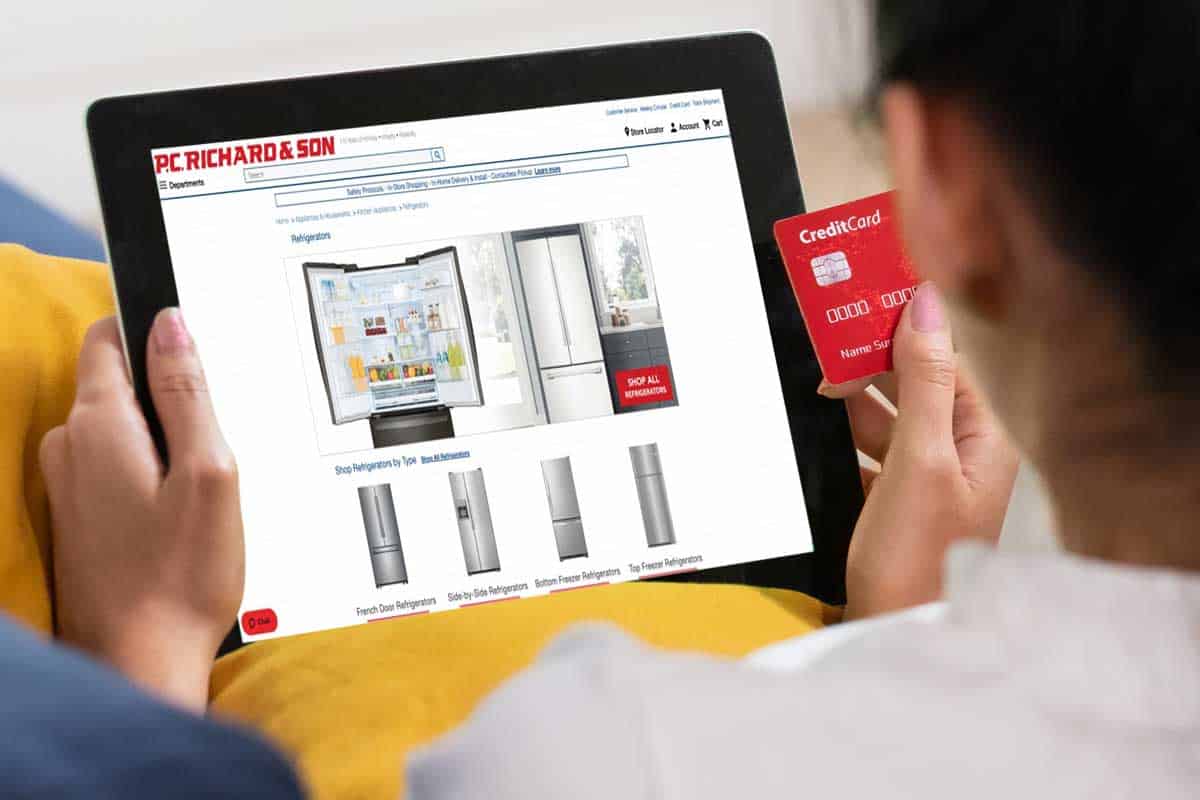 女人网上购物用信用卡购买冰箱平板电脑坐在沙发上在家里,去哪里买冰箱吗?(排名前25位的在线商店)”width=
