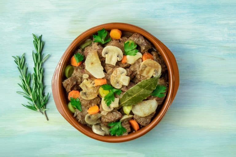 砂锅牛肉和蘑菇蔬菜炖肉菜在一个浅蓝色的表,尺寸做砂锅菜进来吗?