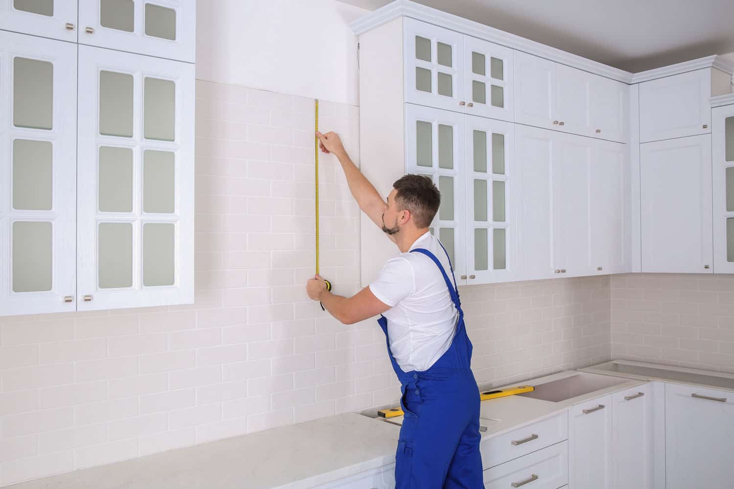 工人在厨房安装新家具时使用卷尺雷电竞官网网址