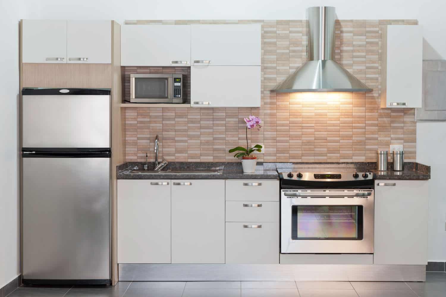 小型现代厨房，配有烤箱，不锈钢罩，白色镶板橱柜雷电竞官网网址