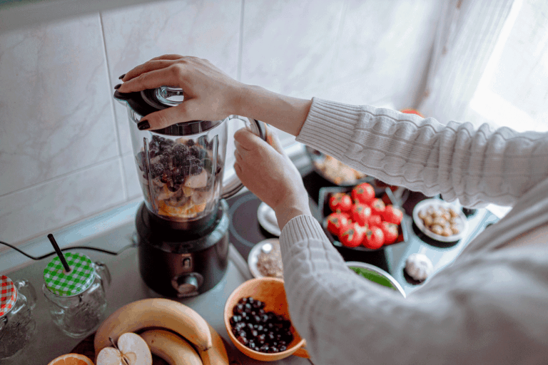 妇女健康和美味的果汁从各种水果和蔬菜在厨房里的电动搅拌机在家里,忍者搅拌器不工作——做什么?雷电竞官网网址