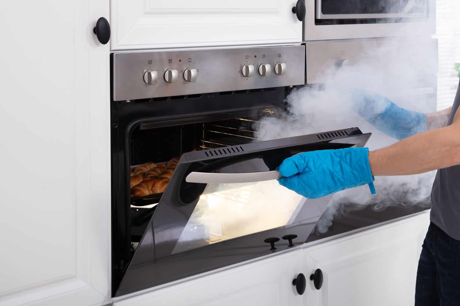 一个男人在检查他正在冒烟的烤箱