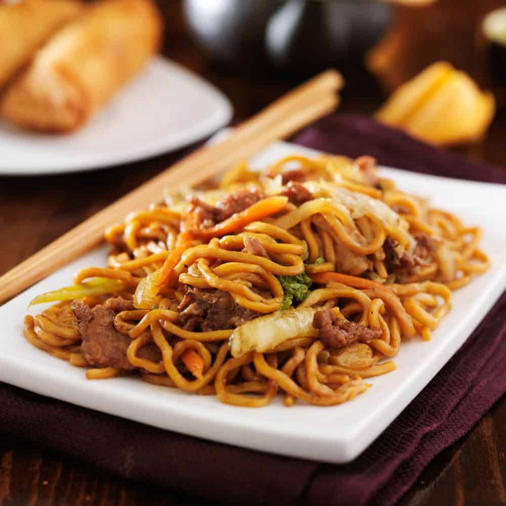 将中国牛肉卤味放在白盘子上炒，筷子放在旁边