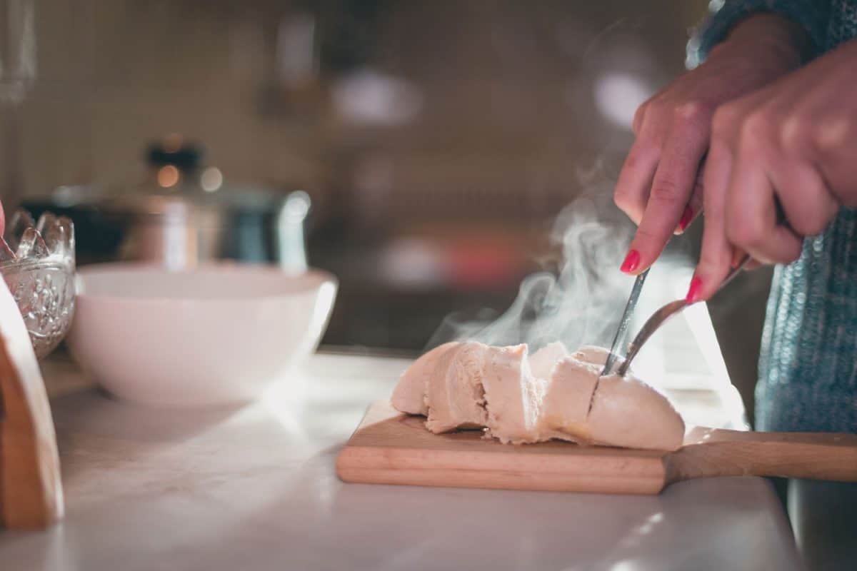 一个女人切鸡在案板上