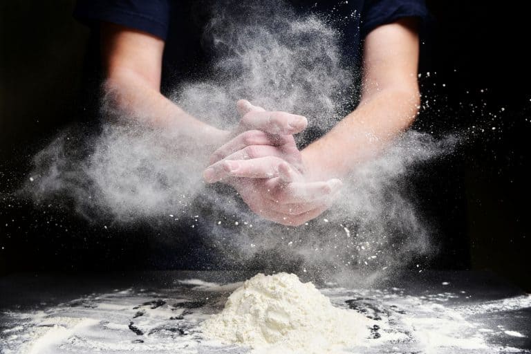 Cook slams splash hands with flour. White dust cloud of flour, Does Flour Brand Matter For Baking?