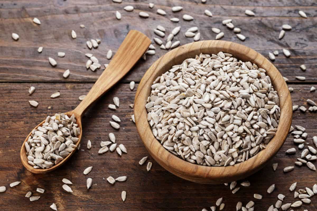 剥了皮的葵花籽放在盘子里的木质背景上