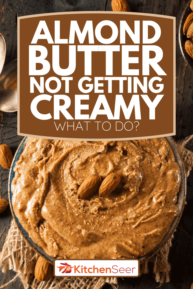 一个生的有机杏仁黄油和杏仁放在木桌上，杏仁黄油不像奶油-该怎么做?