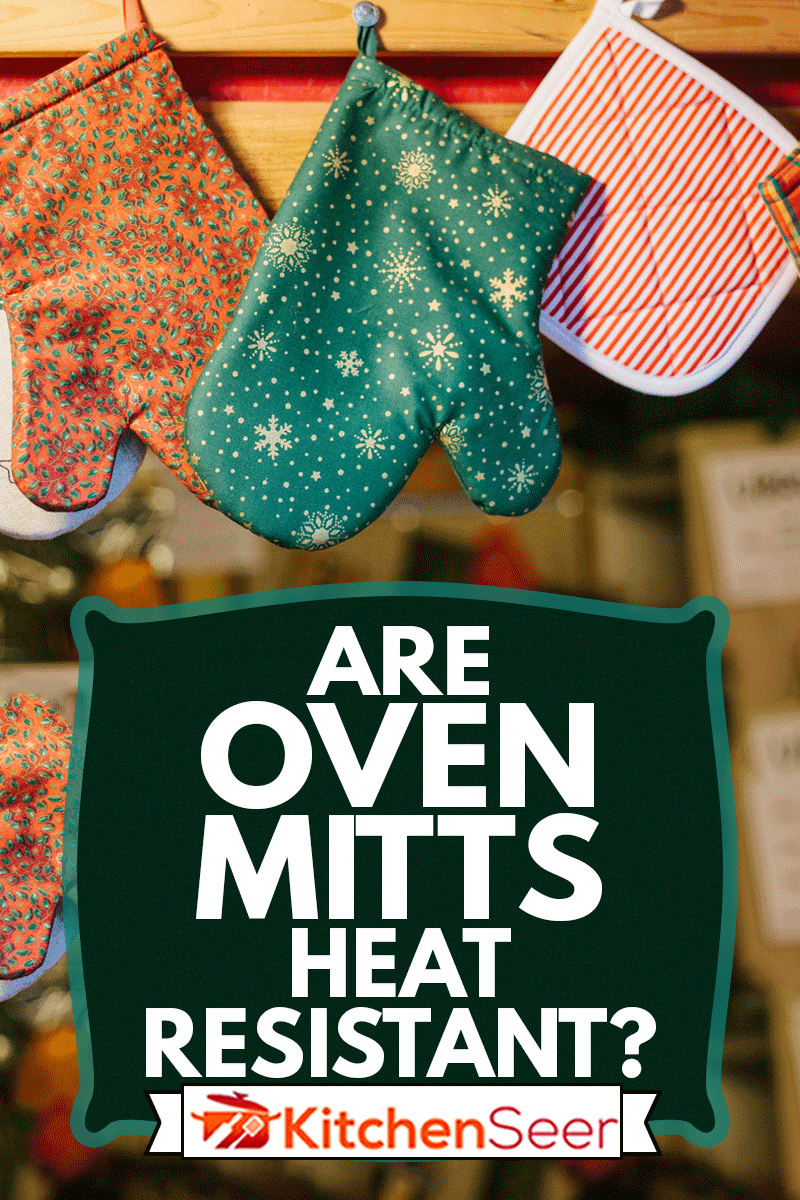 烤箱手套的护套挂在厨房里，背景是模糊的厨房电器，烤箱手套耐热吗?雷电竞官网网址