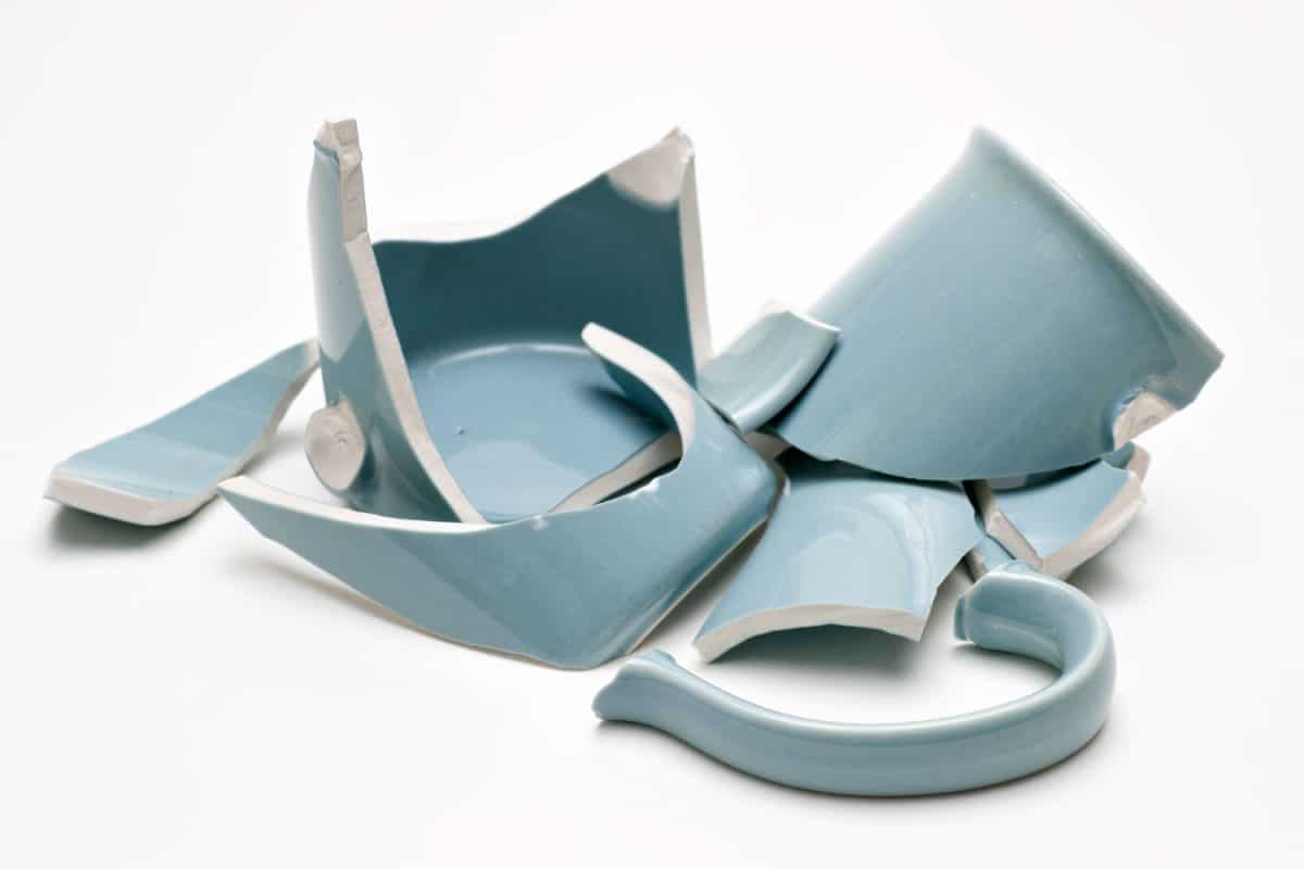 破碎的蓝色的杯子在白色背景