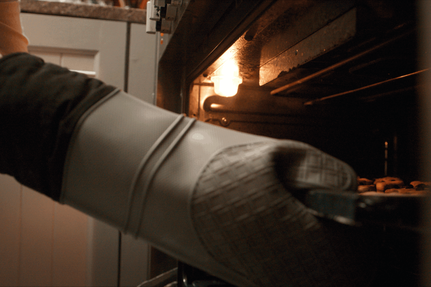 裁剪的一个面目全非的女人把她的饼干从烤箱