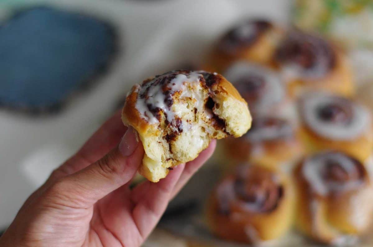 美味的甜面包和肉桂的女人的手