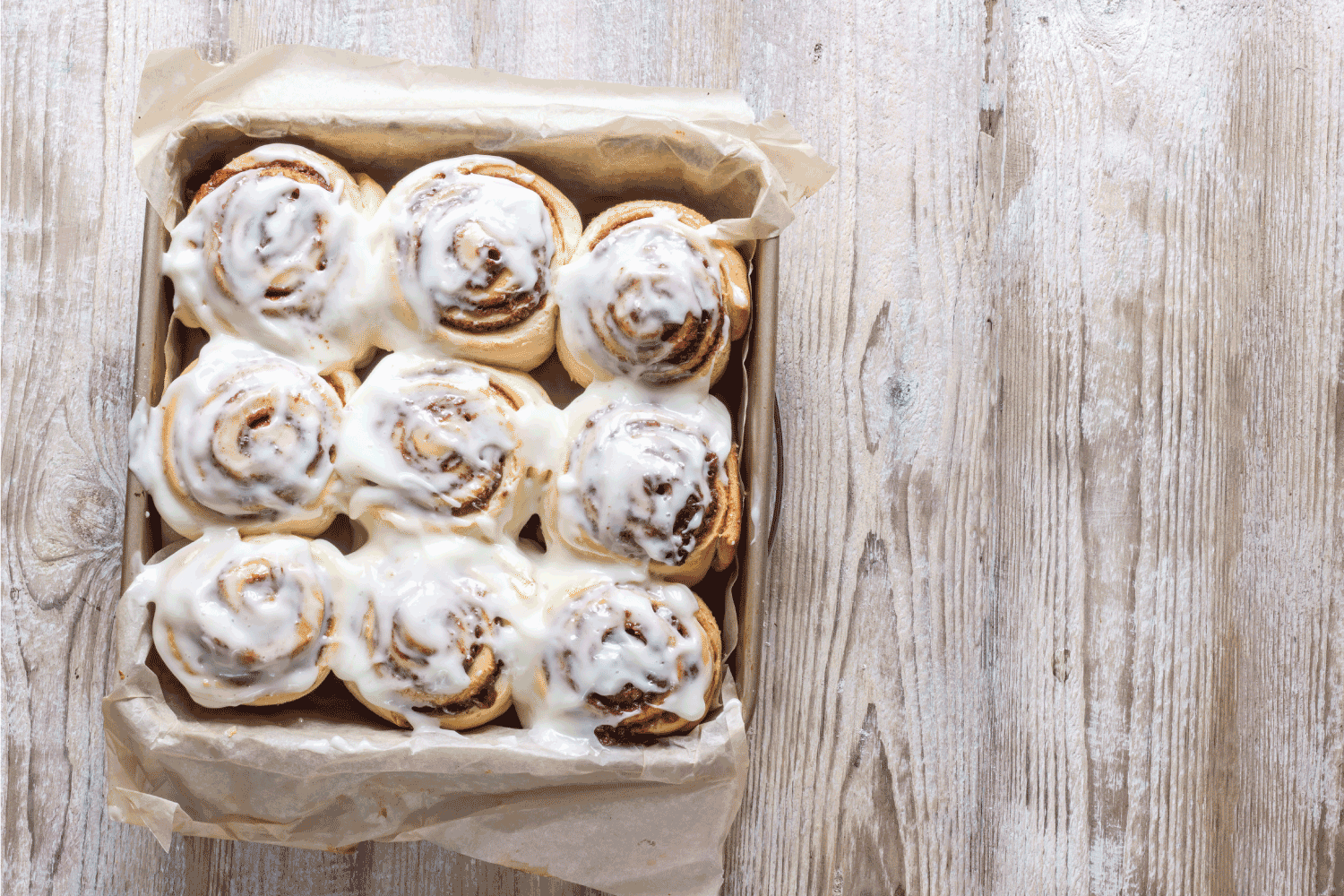 新鲜出炉的肉桂面包与香料和可可填充在羊皮纸上。甜蜜的自制圣诞糕点烘焙