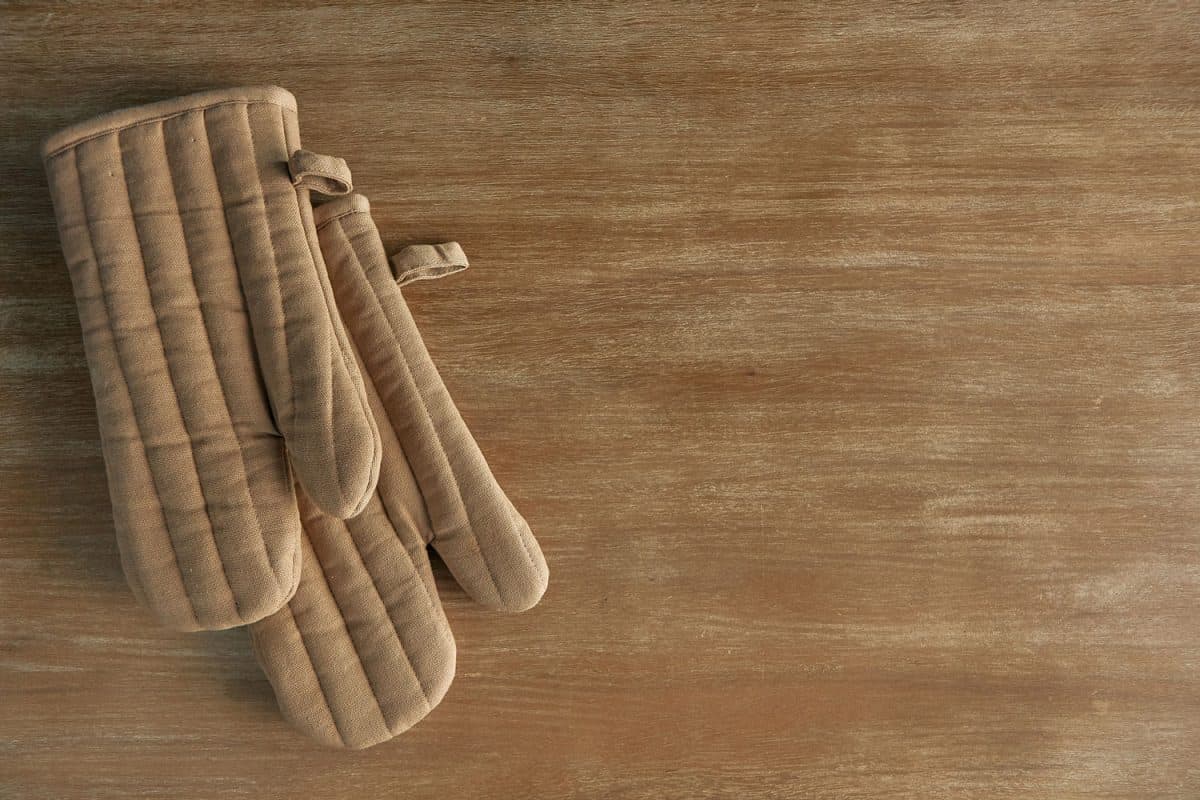 高角度拍摄的一对烤箱手套在烘烤后躺在空厨房台面上雷电竞官网网址