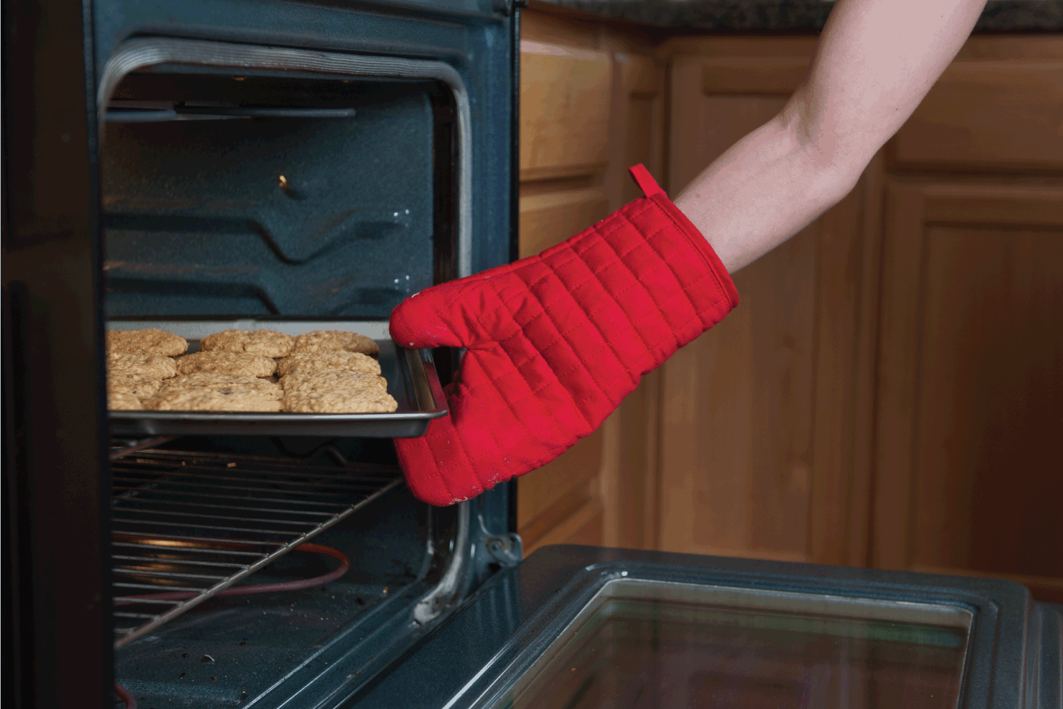 手把饼干从烤箱里取出来。