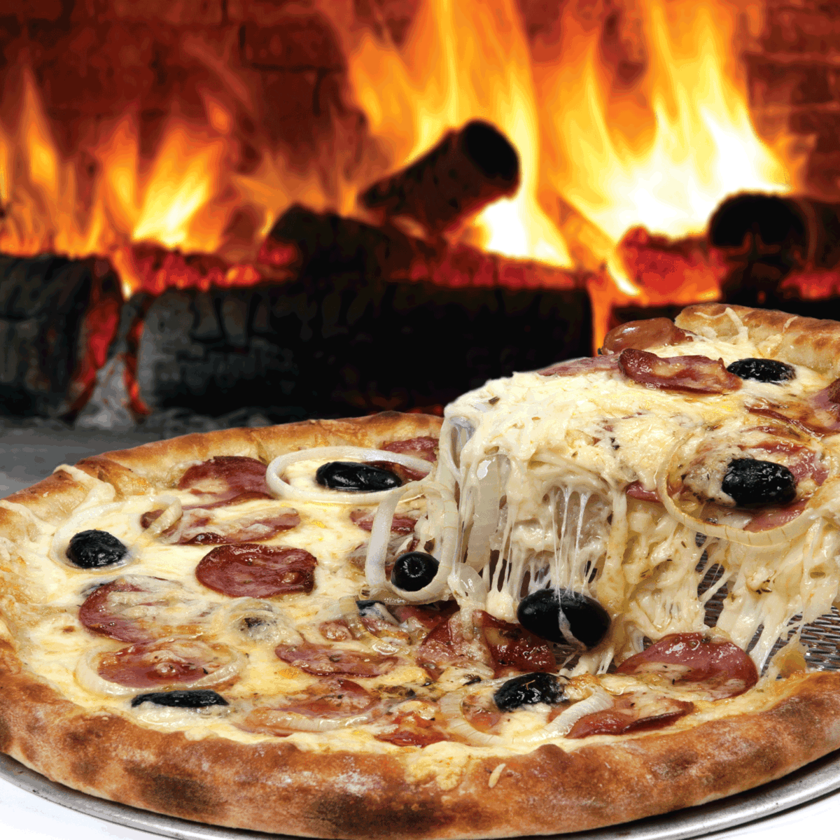 披萨烤箱，披萨放在金属盘上，后面烧木头