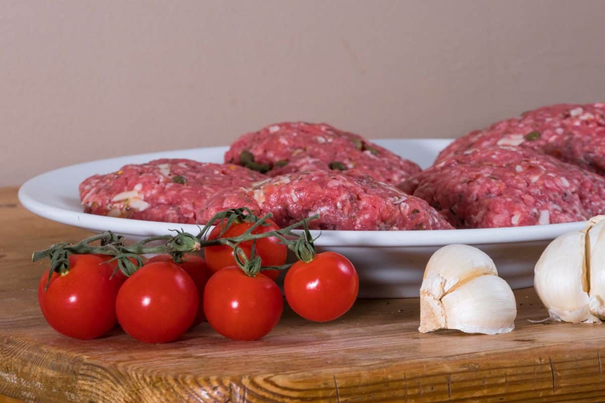 一盘牛肉和其他香料的汉堡肉饼樱桃番茄和大蒜