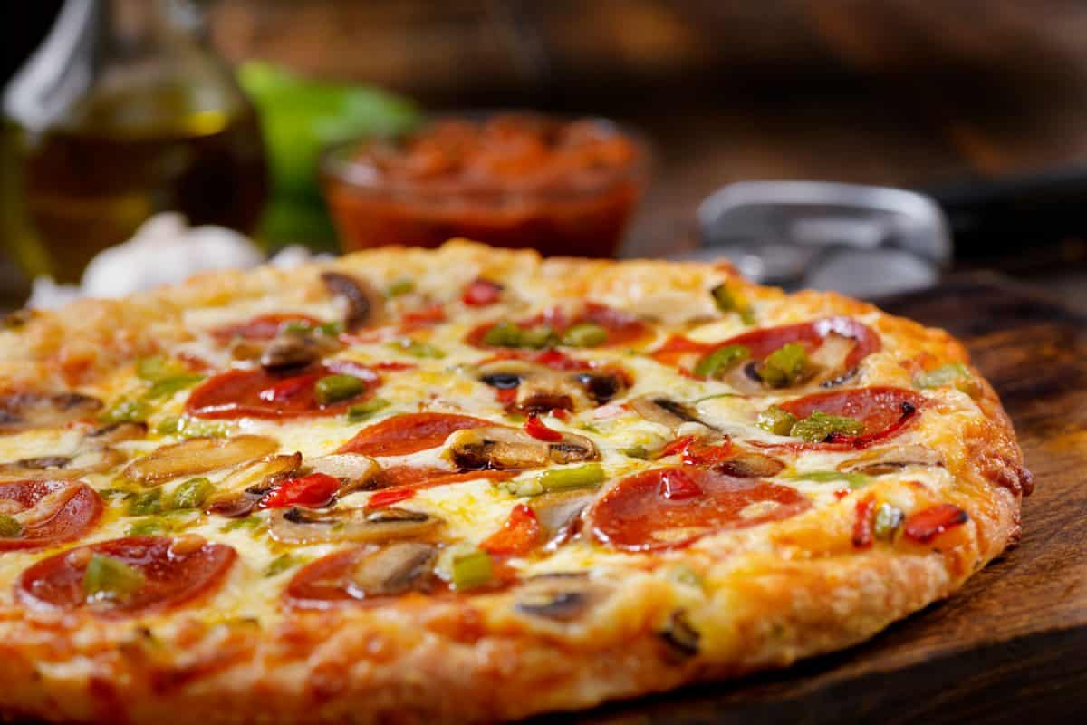 一个近距离的照片与辣椒酱意大利辣香肠比萨饼背景