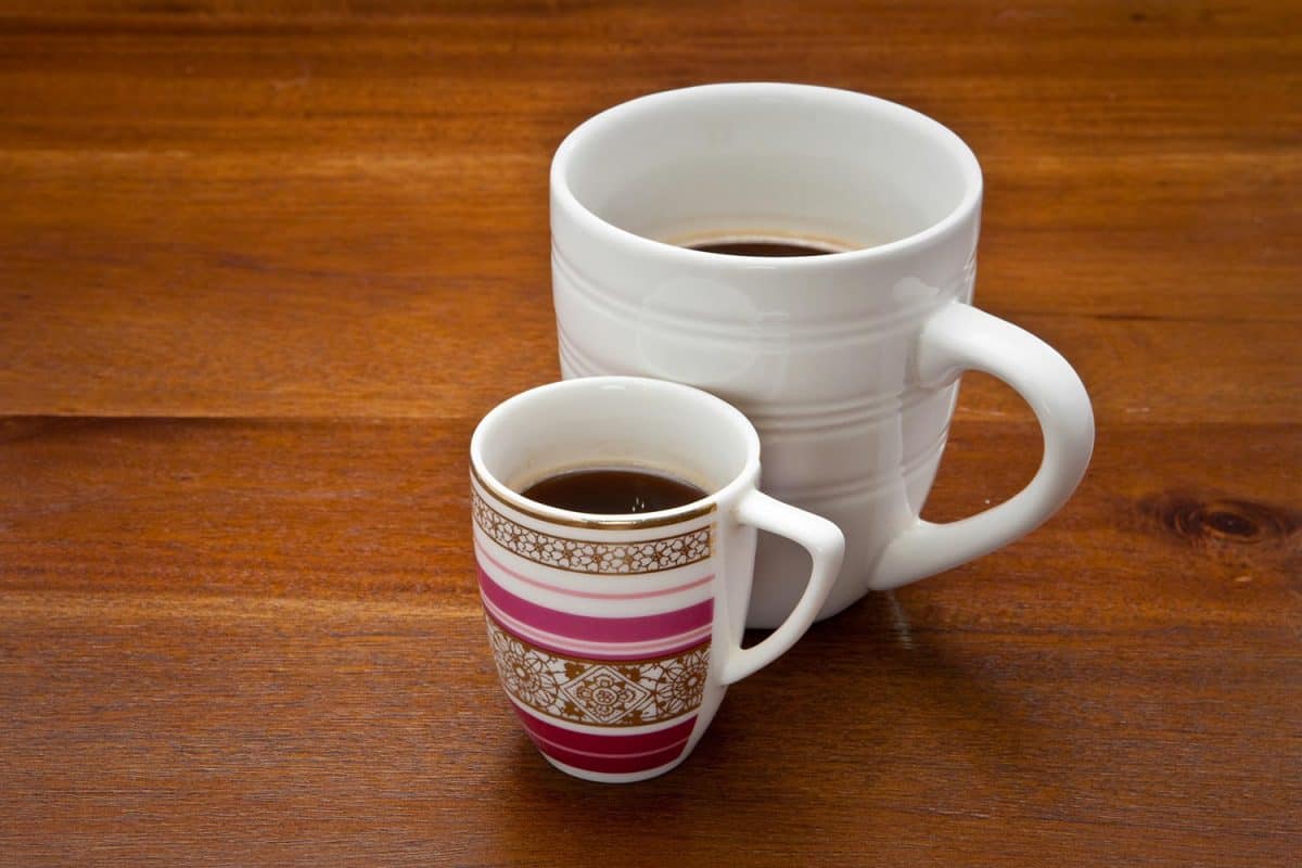 大型和小型咖啡杯在木制的表面上