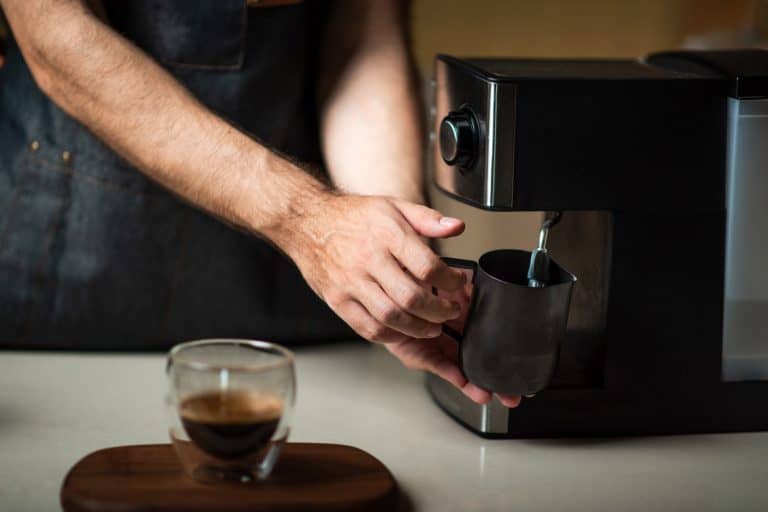 男性咖啡蒸牛奶金属罐子里做卡布奇诺咖啡喝关闭,你应该留下Keurig插入吗?