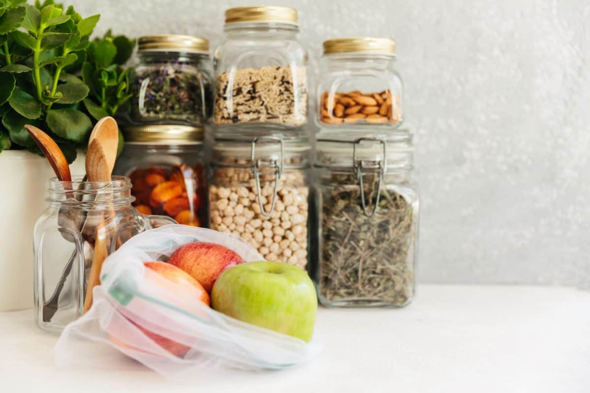 坚果、香料和草药存储在jar容器和苹果在厨房的前面