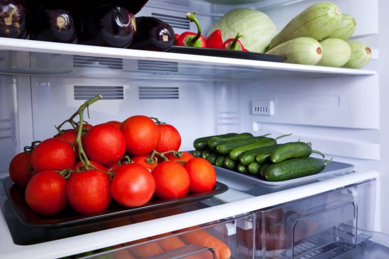 A tray full of tomatoes and cucumbers inside a fridge, Do Tomatoes Last Longer In The Fridge?