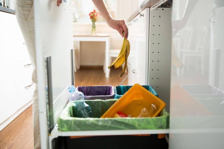 A woman throwing a peeled banana into a trash bin, How To Remove A Built-In Trash Compactor In 4 Easy Steps