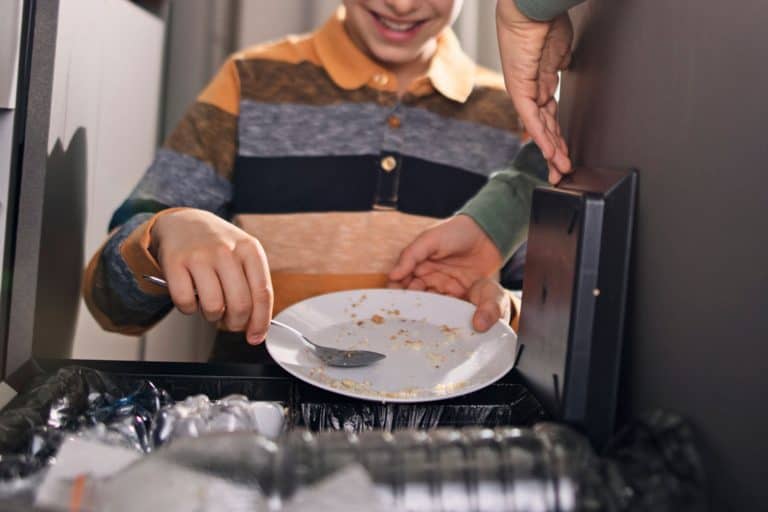 男孩把种族隔离的垃圾。男孩们扔掉的食物浪费垃圾压缩机,一个垃圾压缩机有多重?