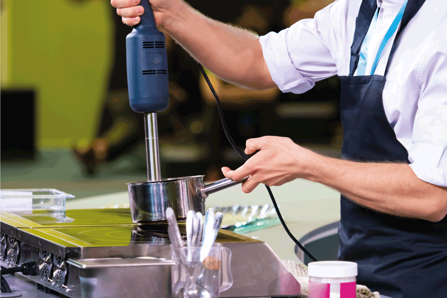 厨师使用搅拌机。厨师用潜水搅拌机工作。销售厨房用具。雷电竞官网网址在餐厅使用搅拌机。磨热的食物