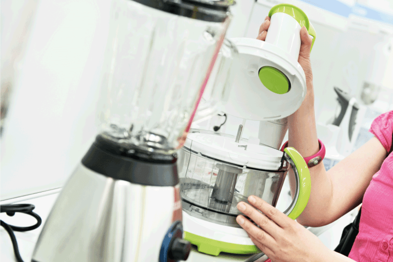 女人在家电超市购物,关注的食品处理器在搅拌机里。你可以运行一个食品加工机多久