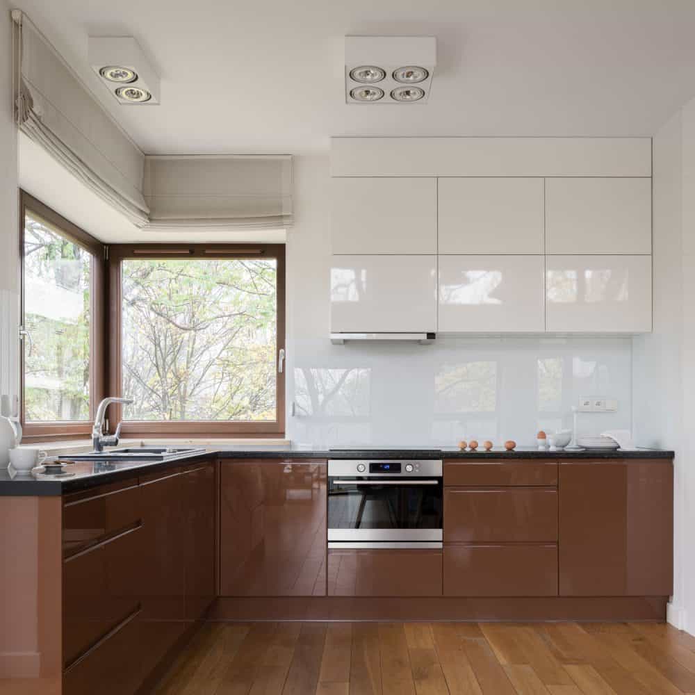 一个小的乡村风格的厨房区域，木地板，棕色漆的低橱雷电竞官网网址柜，黑色花岗岩台面