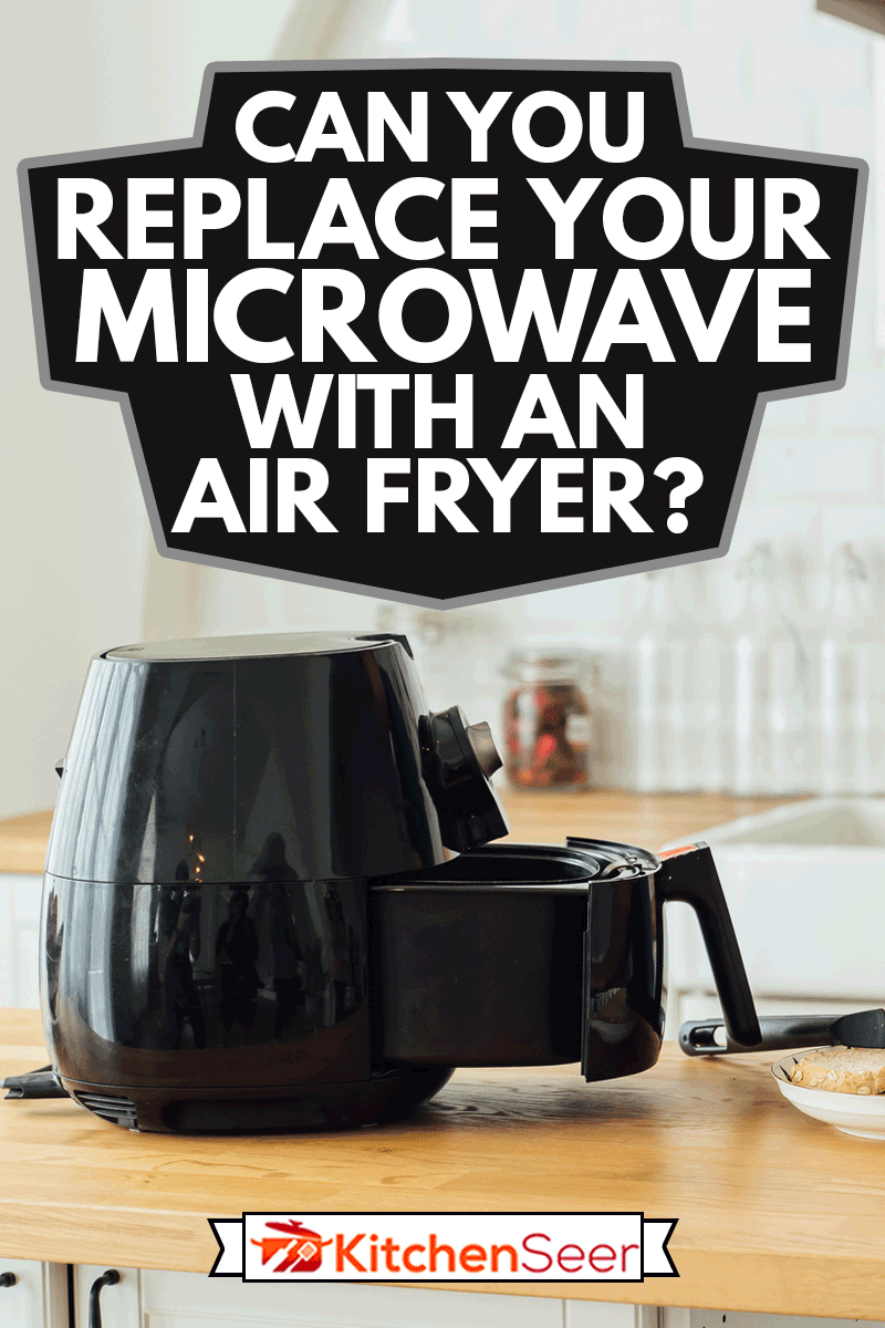 年轻英俊的白人男子看着说明在线笔记本如何使用现代空气炸锅烹饪健康食品不使用石油在家里的厨房里,你能替换你的微波炉和一个空气炸锅吗?雷电竞官网网址