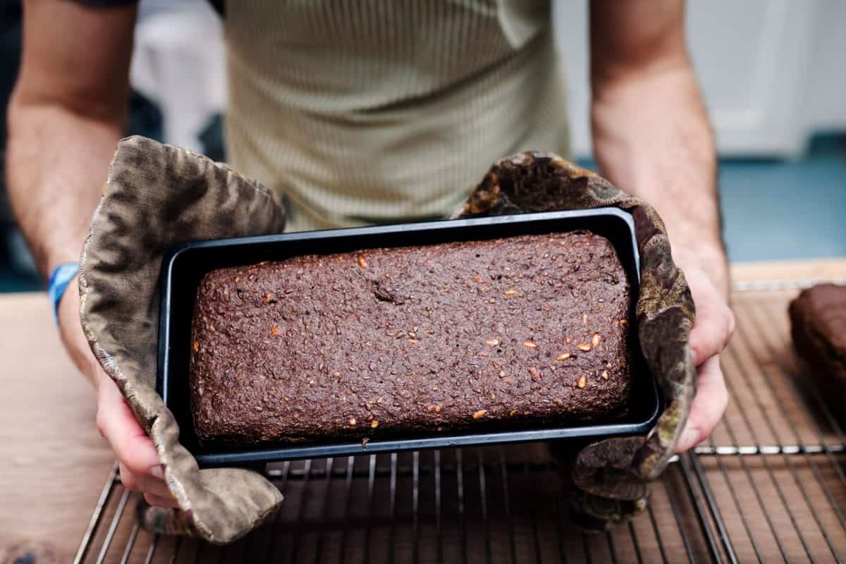 Chef removing freshly baked rye bread