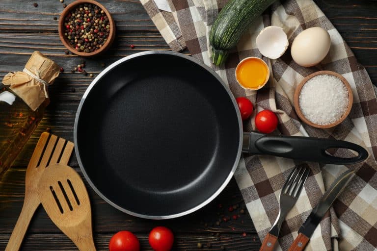 Composition with ingredients for cooking on wooden background with cast iron pan, Should You Season Staub Cast Iron?