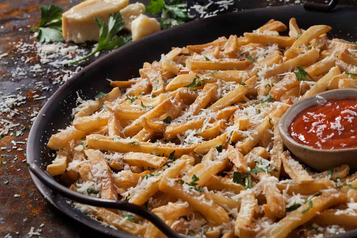 脆皮帕玛森蒜薯条配新鲜欧芹和番茄酱