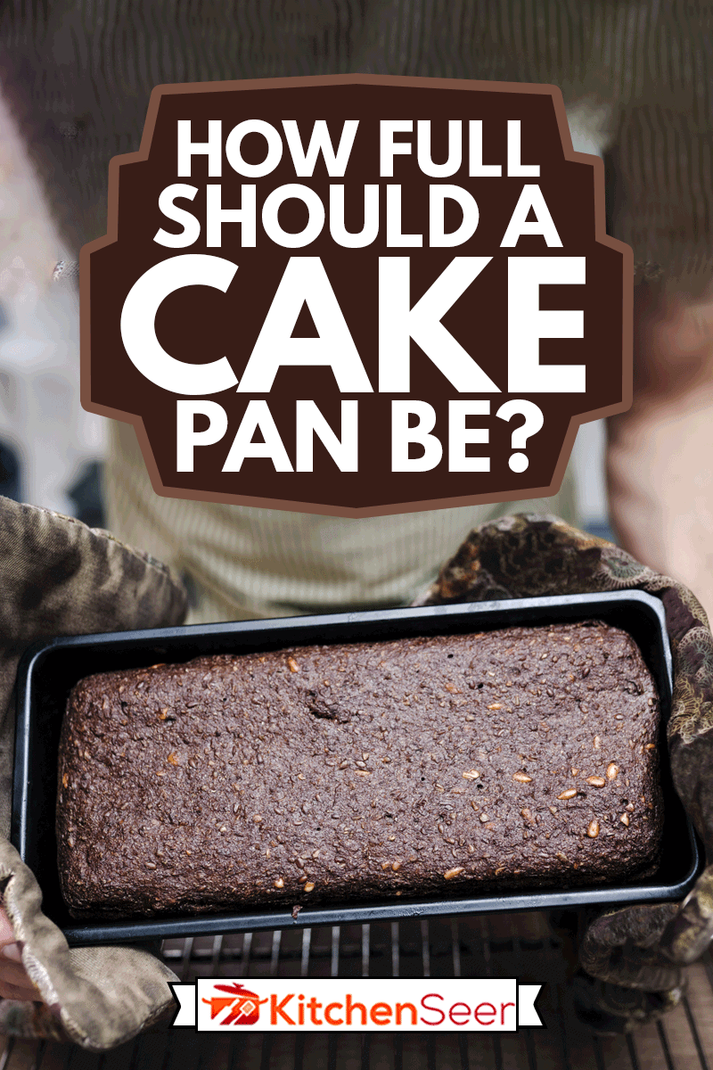 一个刚烤好的黑麦面包的特写，面包师把它从面包盘里摇出来，蛋糕盘应该有多满?