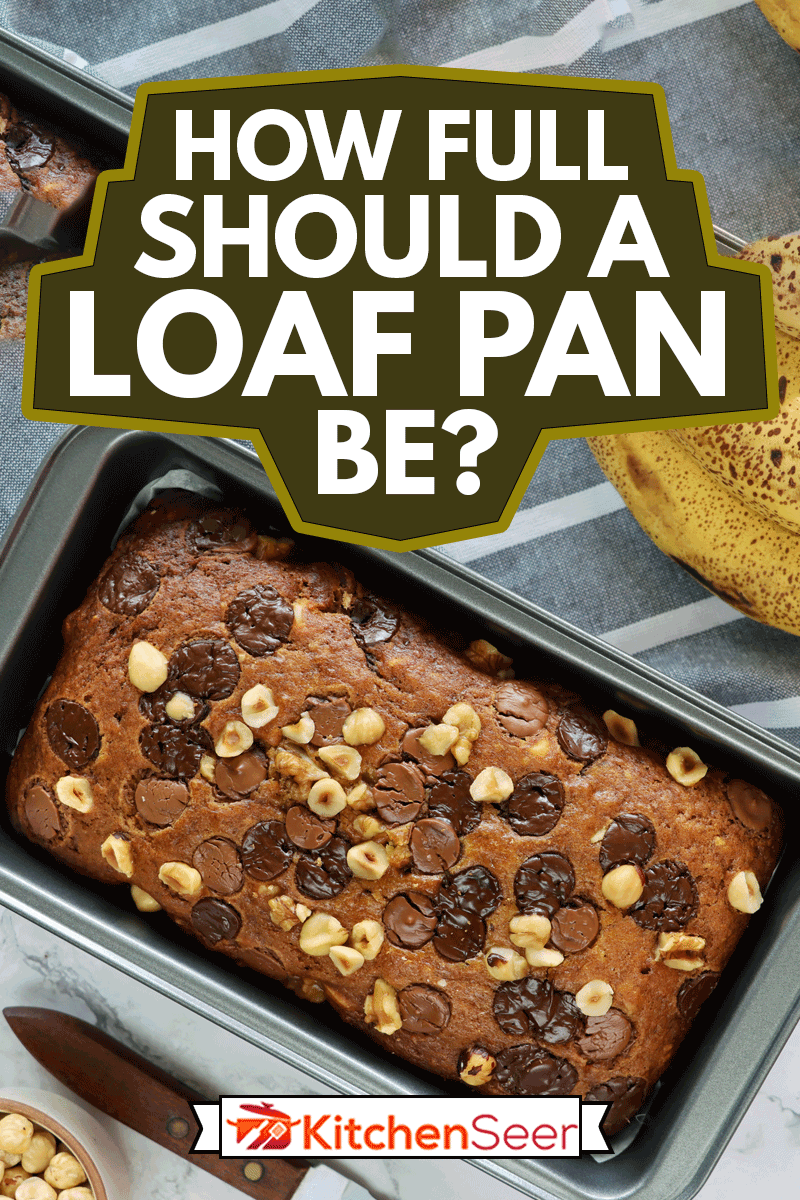 股票照片高架的蛋糕面包含有锡自制的香蕉面包,除了香蕉,一只手碗巧克力和榛果,茶巾,刀,大理石效果的背景。,完整的一块盘应该如何?