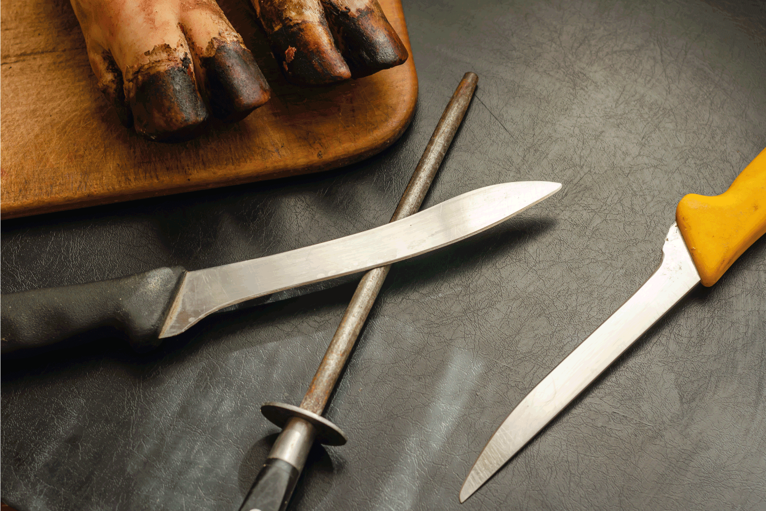 顶部视图照片剔骨刀和珩磨金属旁边的木砧板与猪指关节