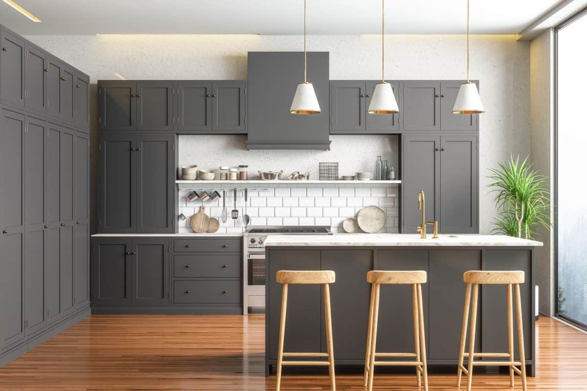 一个乡村风格的厨房，有灰色的橱柜和硬雷电竞官网网址木地板