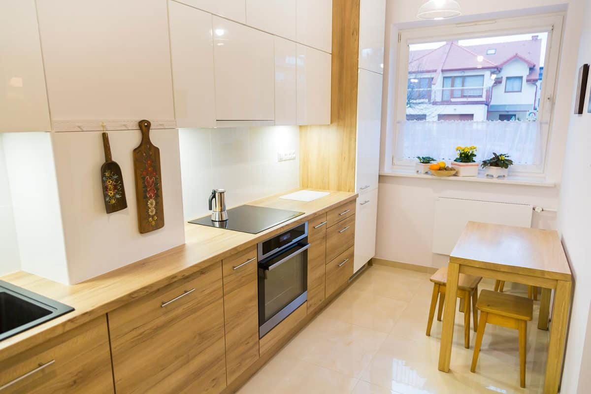 美学现代狭窄的厨房与木制家具雷电竞官网网址＂width=