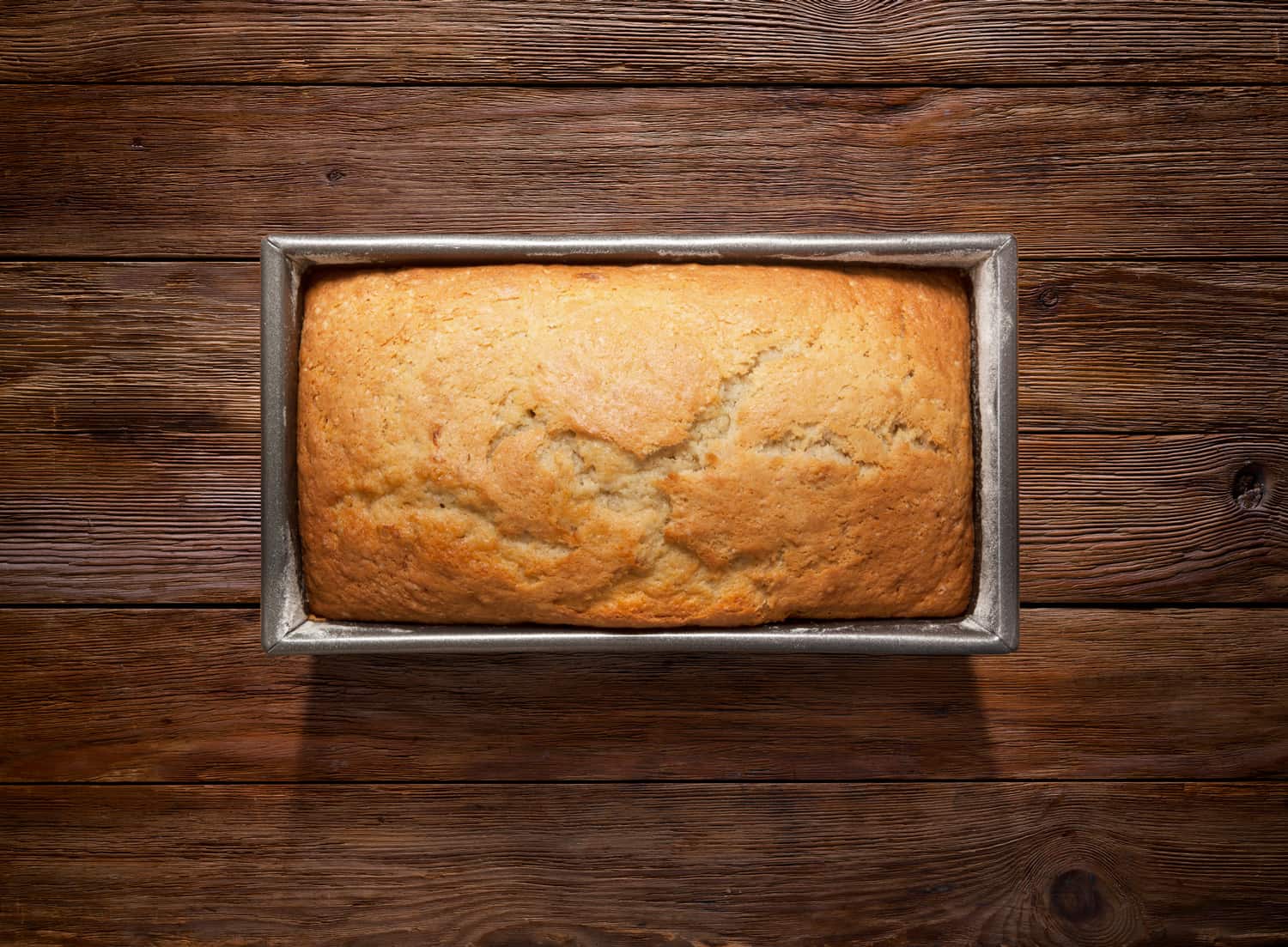 新鲜的蛋糕在面包锅上的木制背景