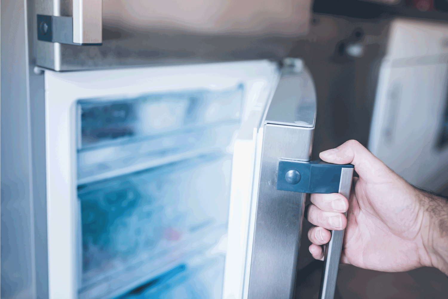 一个男人的手打开厨房的冰柜门雷电竞官网网址＂width=