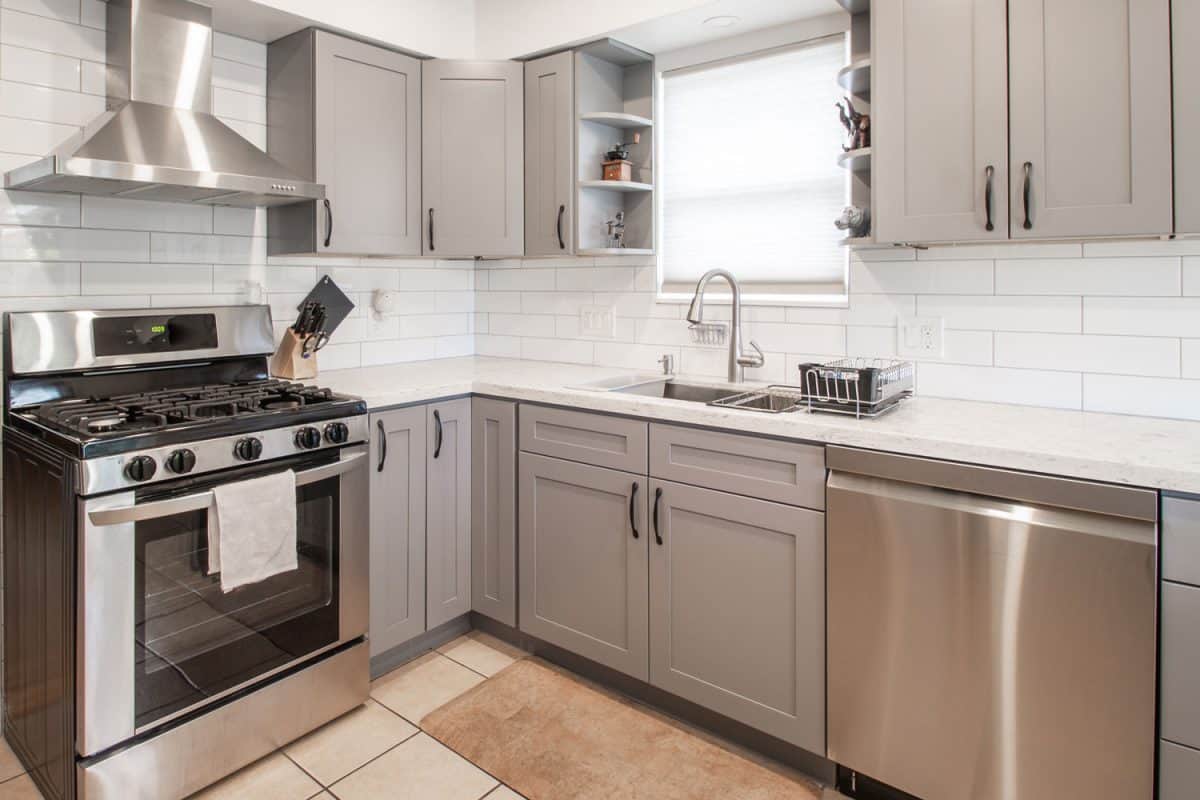 狭窄和乡村主题与白色与灰色的橱柜和厨房橱柜台面雷电竞官网网址