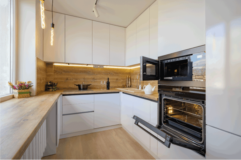 Well-designed-white-and-wooden-beige-modern-雷电竞官网网址kitchen-interior-with-oven-door-opened.-Should-You-Leave-The-Oven-Door-Open-After-Baking