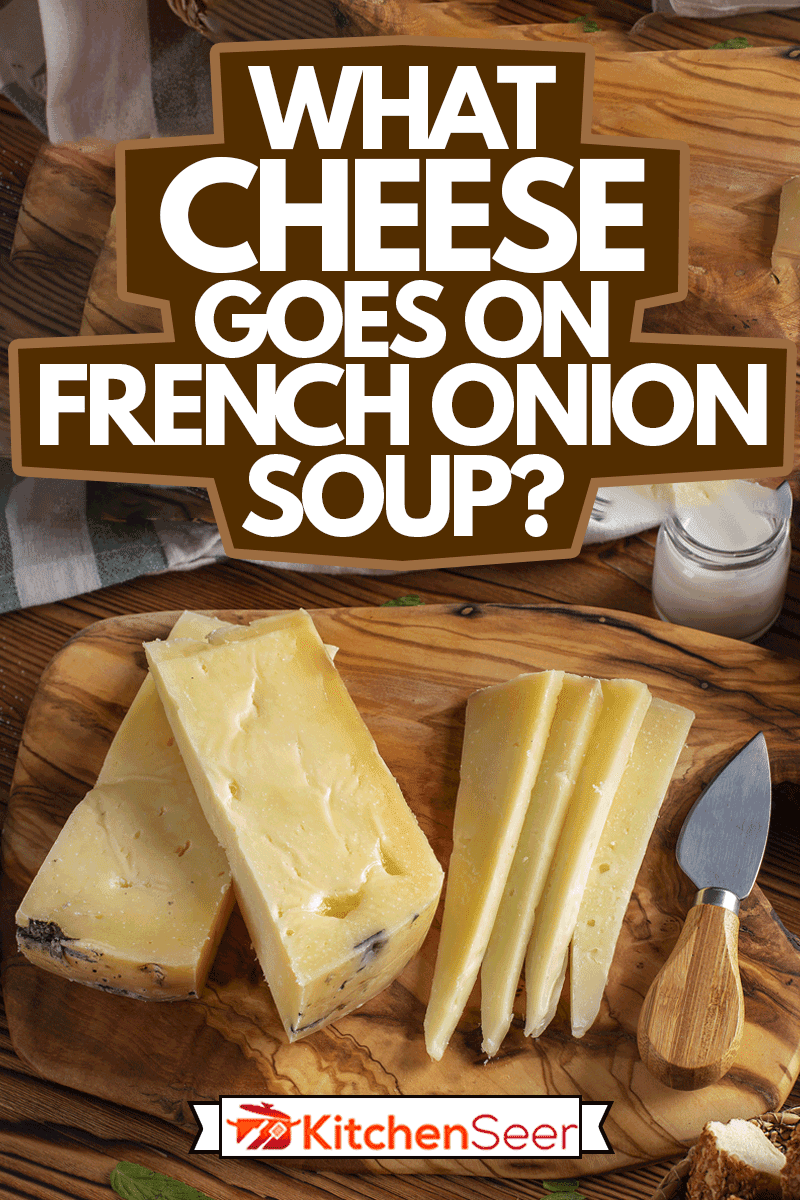 格鲁耶尔奶酪放在木桌上，配有木砧板，刀和道具，法国洋葱汤上有什么奶酪?