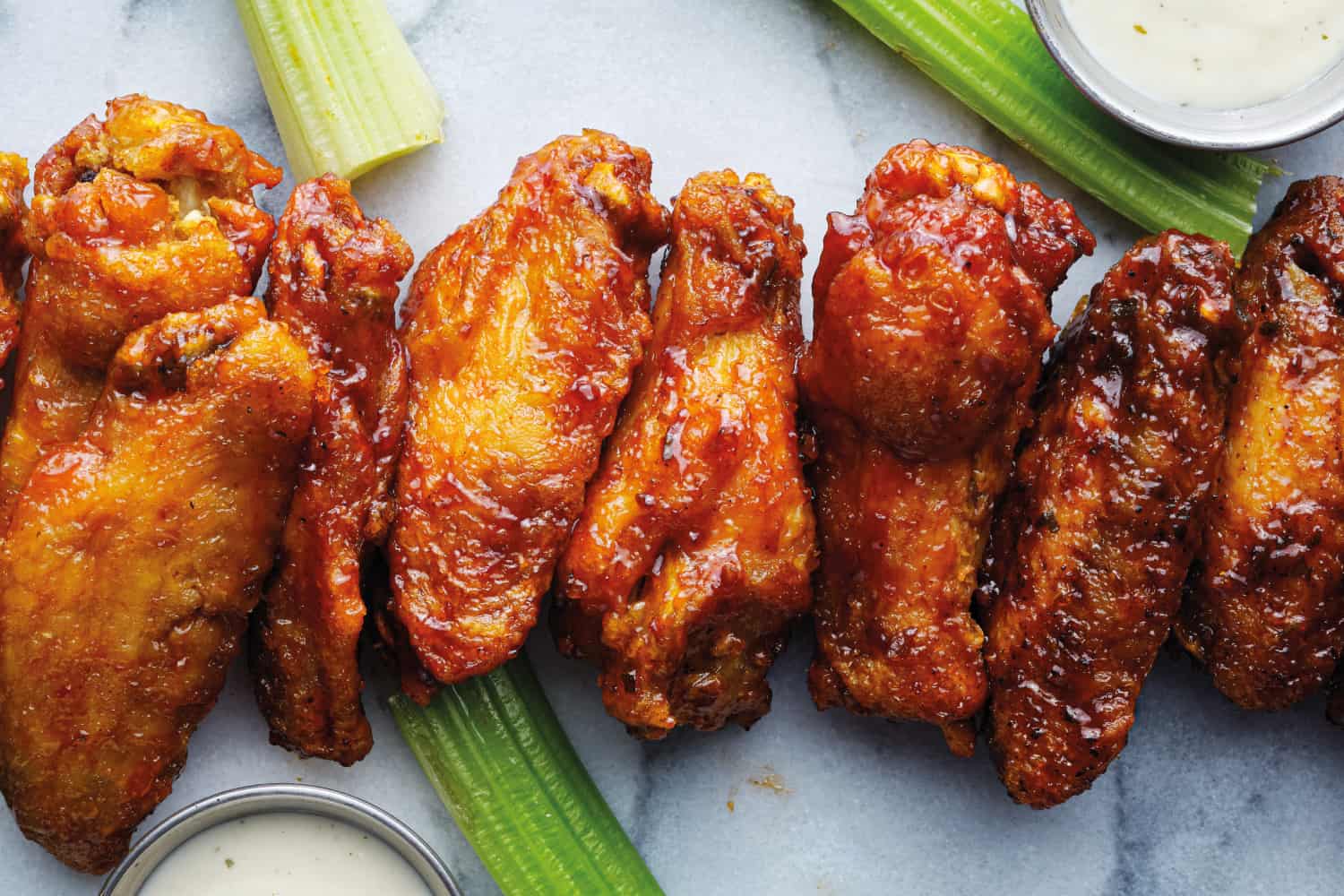 一排水牛城鸡翅浸泡在不同的酱汁自上而下的照片