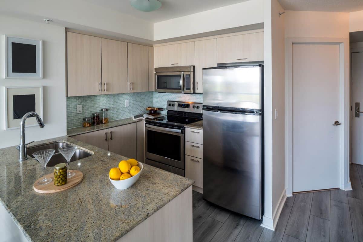 现代厨房小木橱柜,木质地板和一雷电竞官网网址个小冰箱在街角