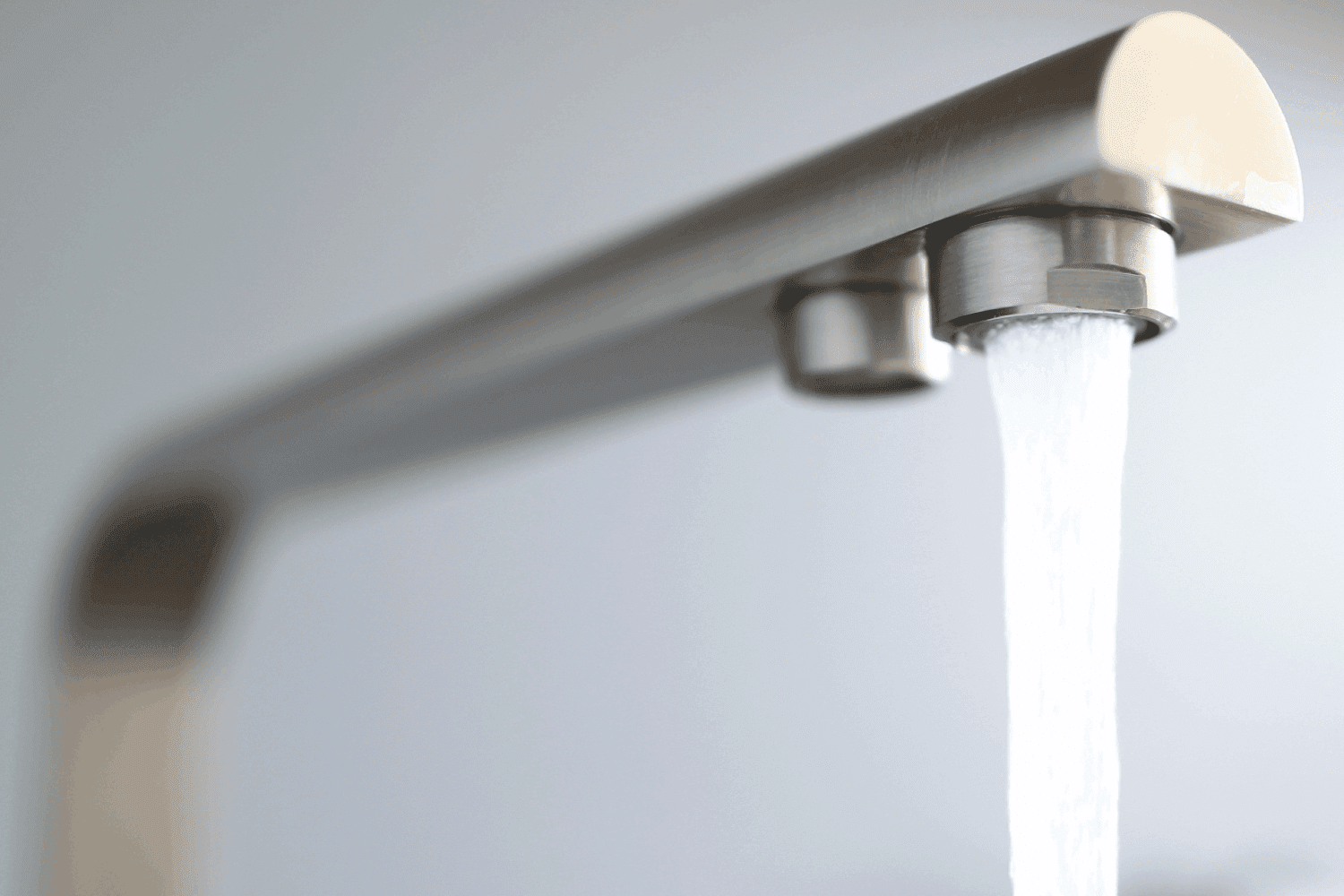 特写喷射水从银在厨房水龙头。雷电竞官网网址正确安装搅拌机,避免泄漏。水过滤系统在厨房的一所公寓里雷电竞官网网址